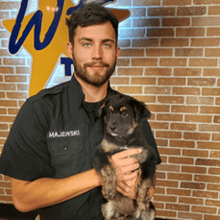 Zac, a volunteer at the rescue centre, holding a dog