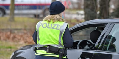 Polizistin steht an Auto