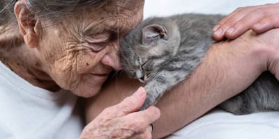 Alte Frau kuschelt mit Katze