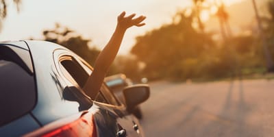 Arm wird aus offenem Autofenster gehalten