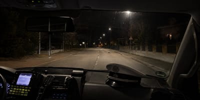 Blick aus Polizeiauto auf dunkle Straße