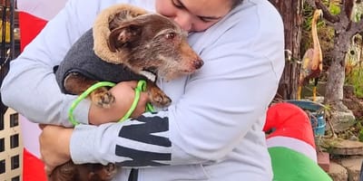 Chien prénommé Choco tenu dans les bras d’une femme, moment d’émotion après quatre ans de séparation