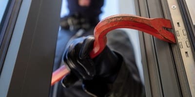 Einbrecher öffnet Tür mit Brecheisen