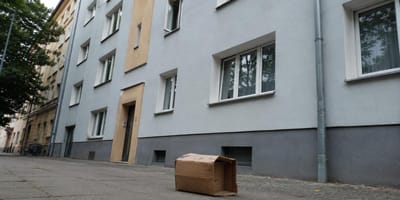 Karton steht auf einem Gehweg