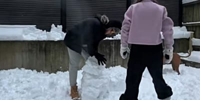 Paar baut einen Schneemann im Garten