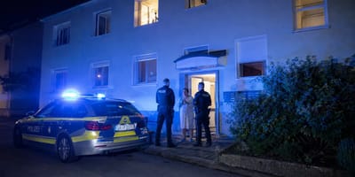Polizei nachts vor einem Mehrfamilienhaus