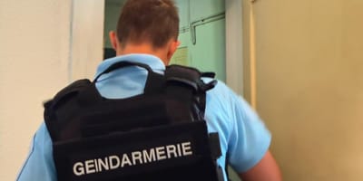 Un gendarme devant une maison