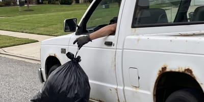 Ein Mann wirft einen Sack aus einem Auto