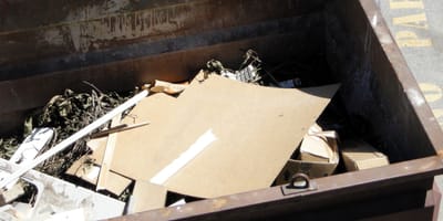 A cardboard box inside a dumpster
