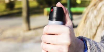 Weibliche Hand mit Pfefferspray