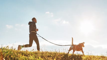 Mann rennt mit Hund