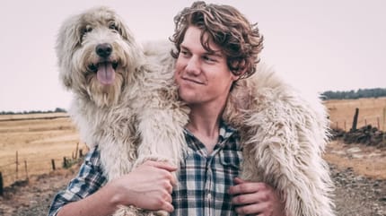 uomo con cane sulle spalle