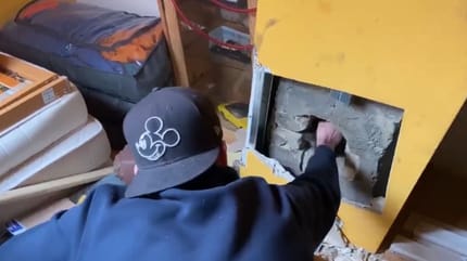 Mann greift in Kamin