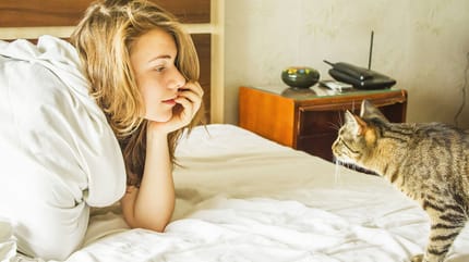 donna e gatto sul letto
