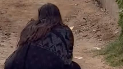 Frau kniet auf Straße