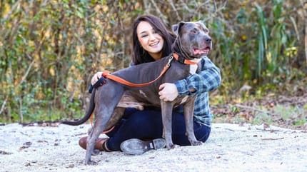 Frau hat Hund auf dem Arm