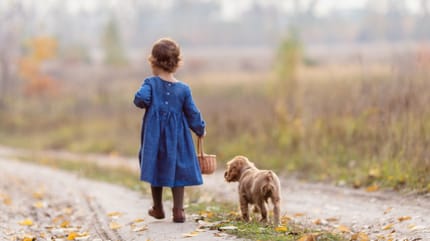 Kleines Mädchen geht mit Hund spazieren