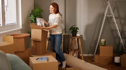 Frau findet Buch in Umzugskartons