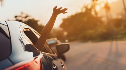 Arm wird aus offenem Autofenster gehalten