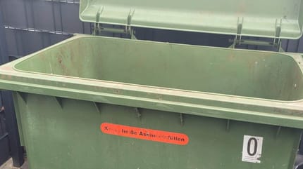 Offenstehender grüner Müllcontainer