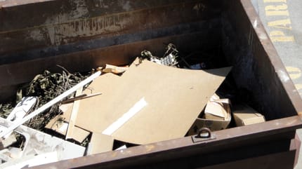 Une boite en carton dans une poubelle