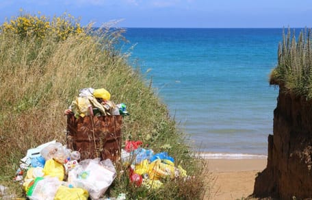 Überfüllter Mülleimer am Strand