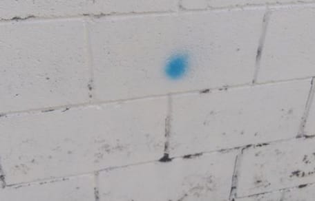 Eine blaue Markierung an der Hauswand.