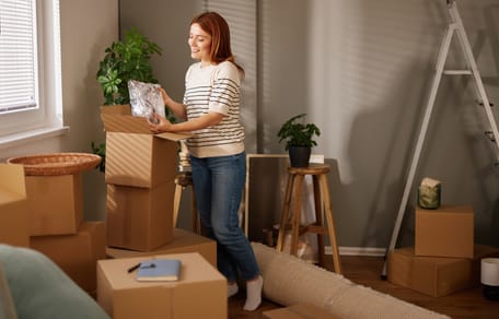 Frau findet Buch in Umzugskartons