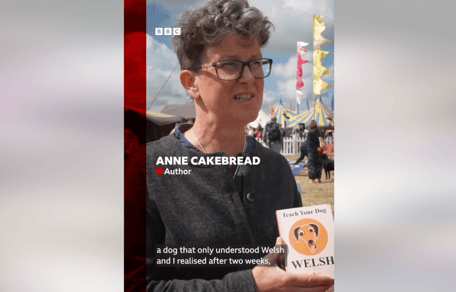 Anne Cakebread holding a copy of her book "How to teach your dog Welsh"