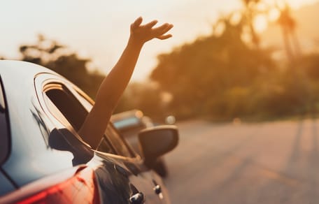 Arm wird aus offenem Autofenster gehalten