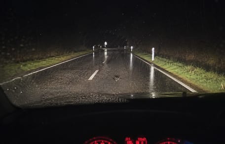 Autofahrer bremst auf dunkler, nasser Straße