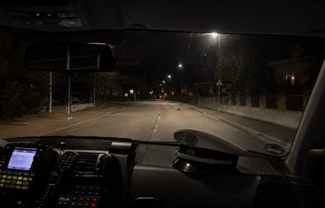 Blick aus Polizeiauto auf dunkle Straße