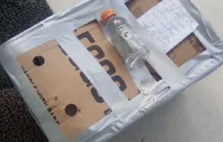 Wasserflasche und Notiz auf dem Karton