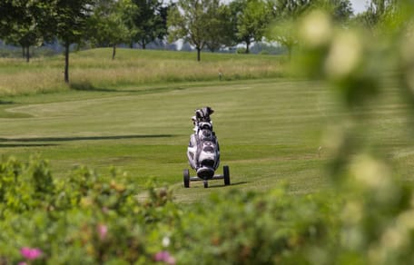 Einsamer Caddy auf einem Golfplatz