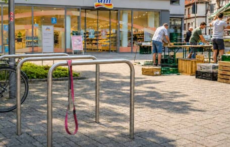 Fahrradständer, über dem eine rosa Hundeleine hängt