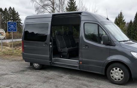 Furgonetka Sprinter z otwartymi drzwiami bocznymi na granicy
