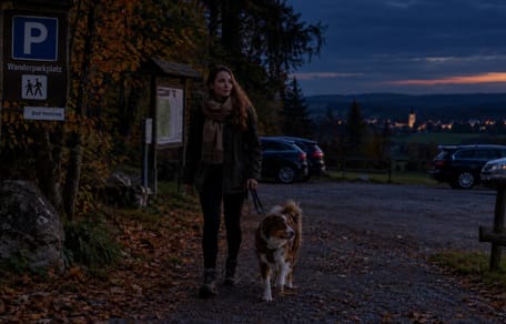 Frau mit Hund beim Abend-Gassi