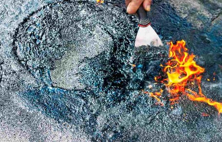 Heißer Teer mit züngelnder Flamme