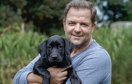 Martin Rütter mit einem Welpen