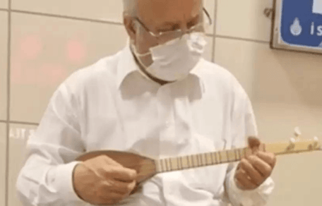Street cat sleeping on musician's instrument case in underground station