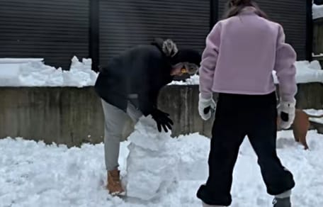 Paar baut einen Schneemann im Garten