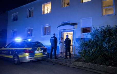 Polizei nachts vor einem Mehrfamilienhaus