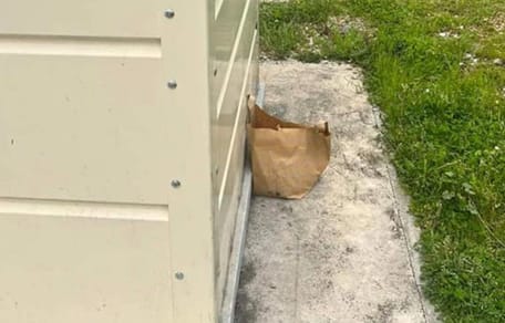Papiertüte neben einem Glascontainer
