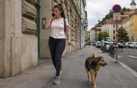 Telefonierende Frau geht Gassi