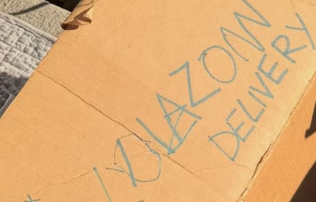 Una scatola abbandonata davanti a un rifugio con un biglietto