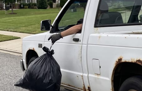 Un homme jette un sac d'une voiture