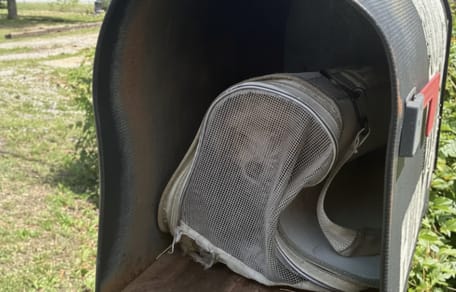 Een dichtgeritste tas in een brievenbus