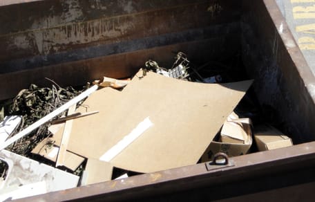 A cardboard box inside a dumpster