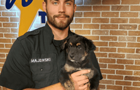 Zac, volontario del rifugio, con un cane tra le braccia