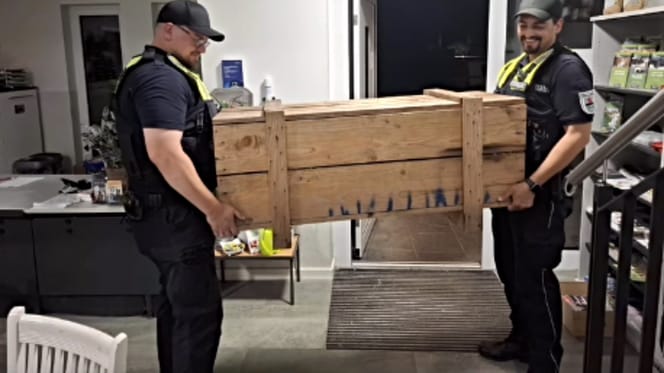 2 Männer tragen große Holzkiste